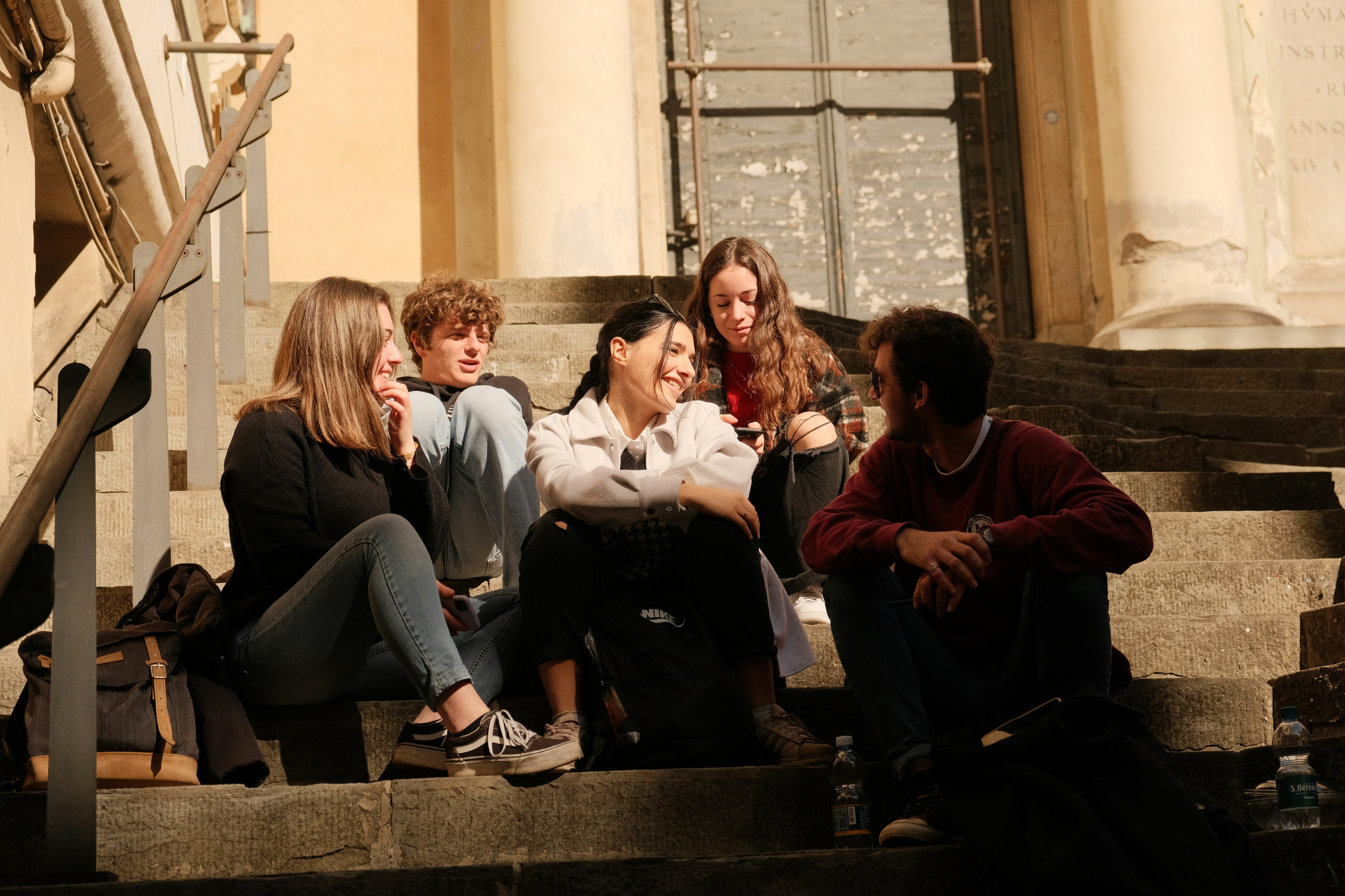 Group of youth sitting together on outdoor steps.