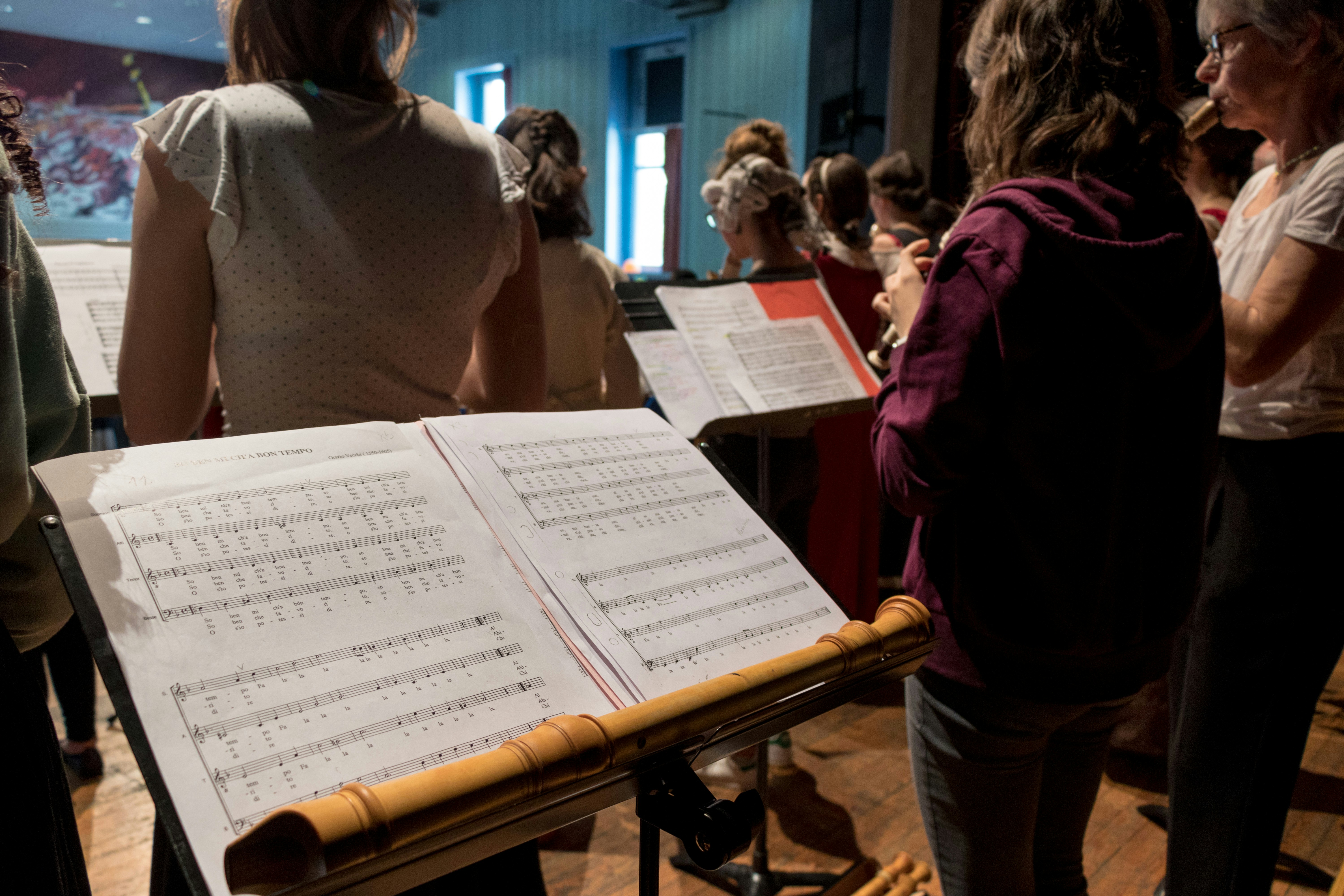 Children standing with music stands and reading from music sheets.